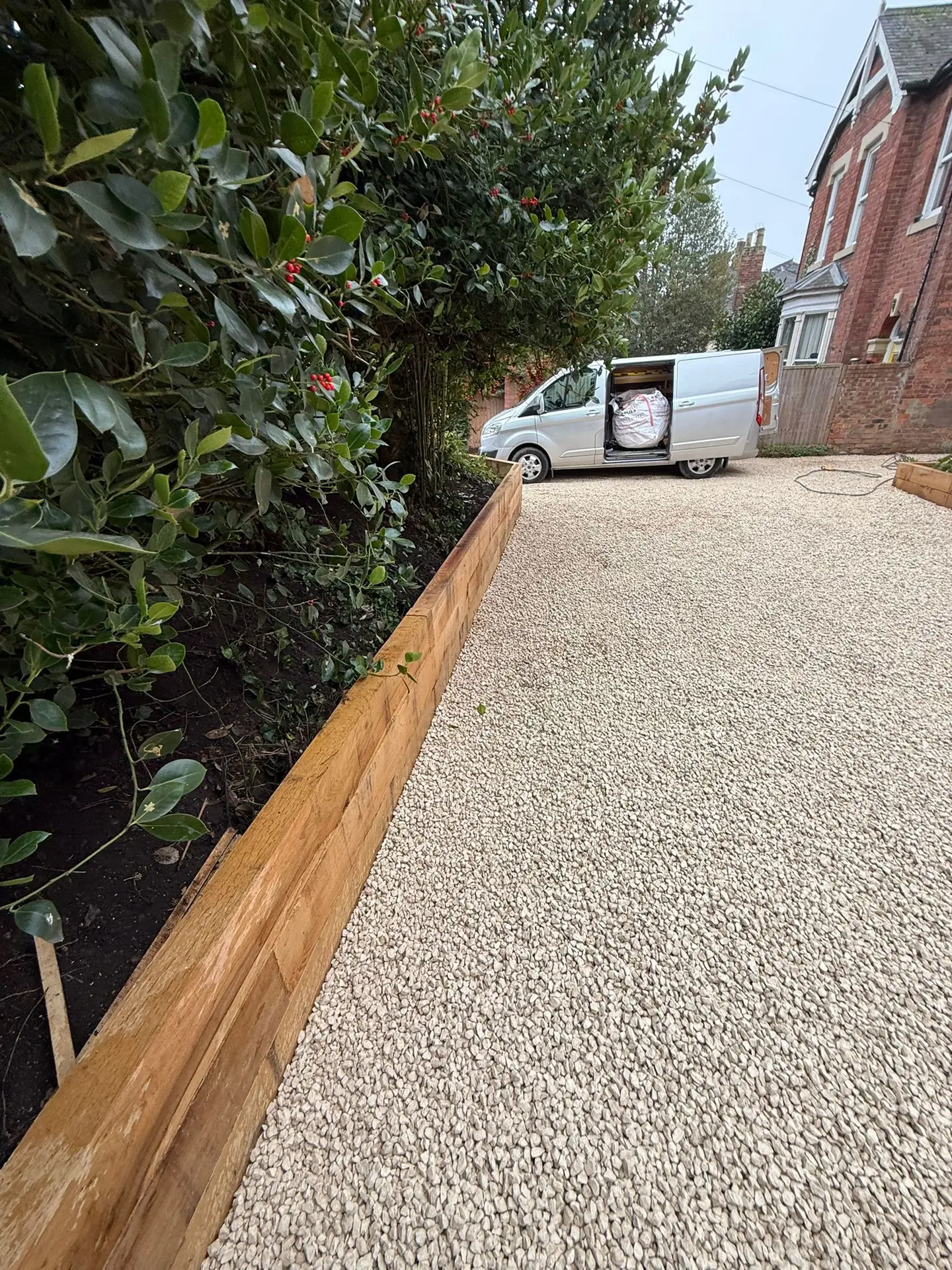 Modern gravel driveway with timber retaining walls installed by Reshape Landscaping in Lincoln, creating a clean, low-maintenance outdoor space.