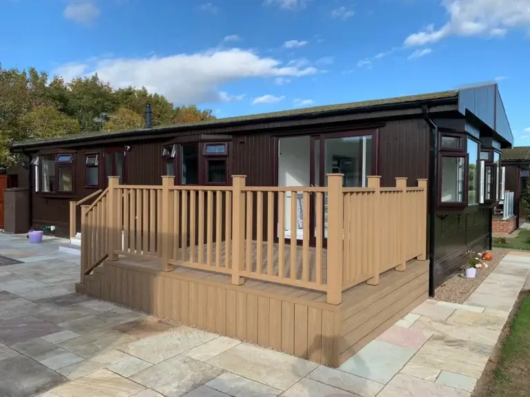 Composite decking platform and balustrade installation in Lincoln by garden landscapers in Lincoln, adjoining a sandstone patio with modern garden layout