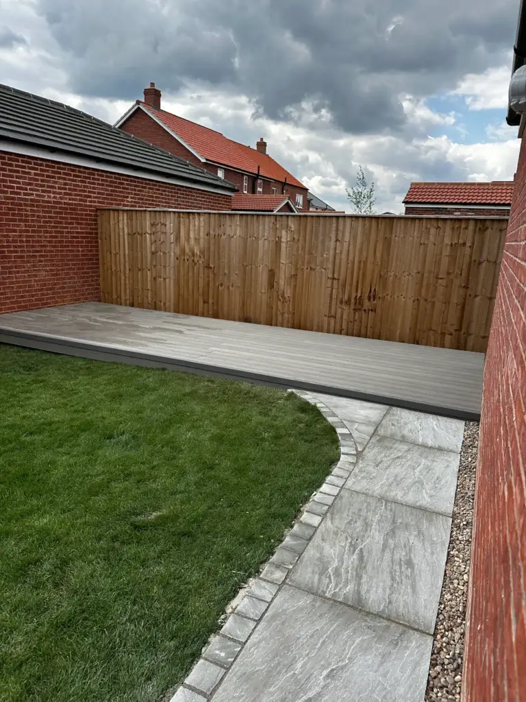 Garden design in Lincoln by garden landscapers in Lincoln. Featuring light grey porcelain paving, composite decking, and new turf lawn