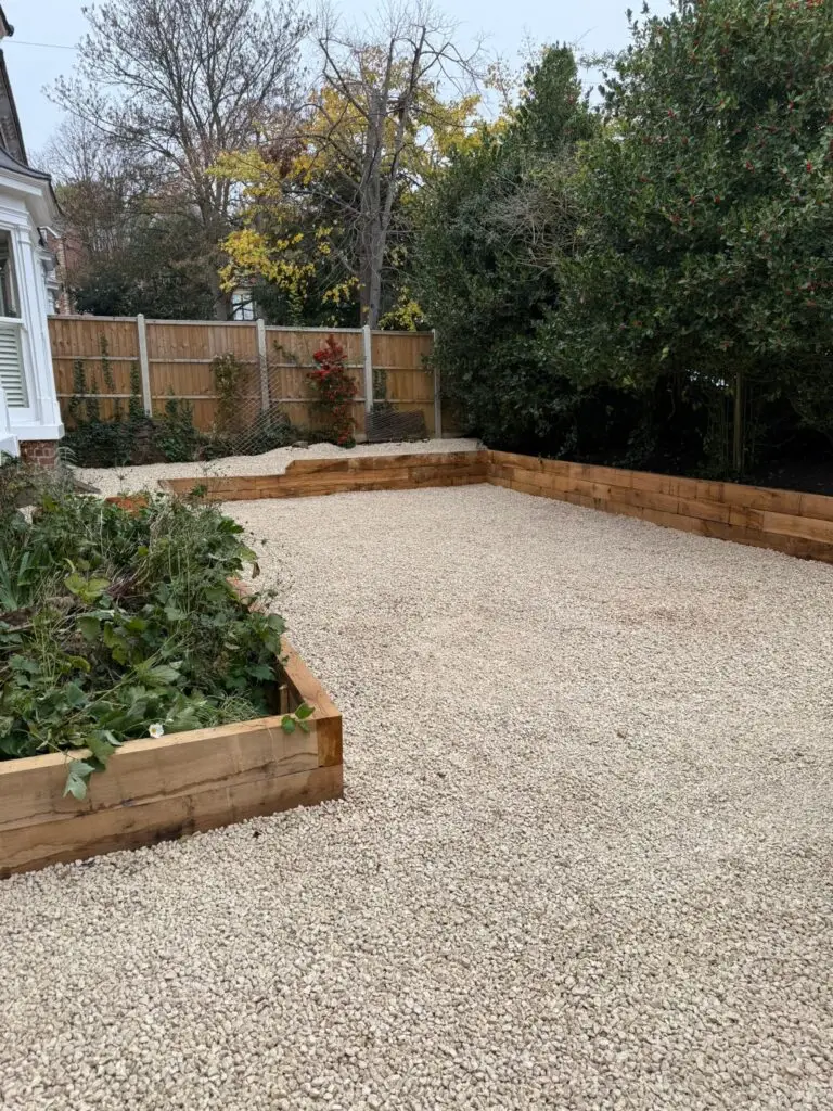 New front garden gravel driveway installation in Lincoln with wooden sleeper retaining wall installed by landscapers in Lincoln, showing a neat, modern finish