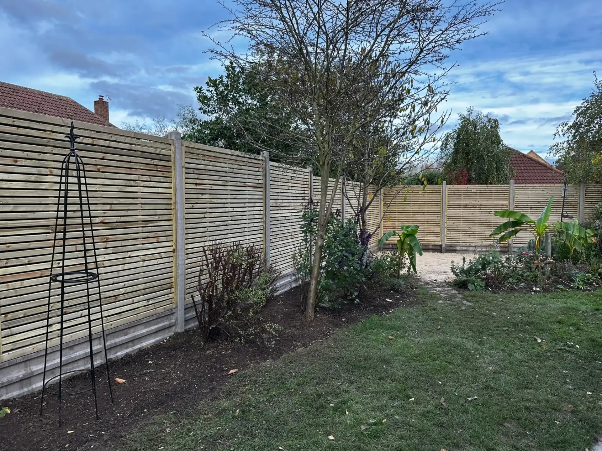Landscape gardeners in Lincoln installing modern horizontal slatted timber fencing