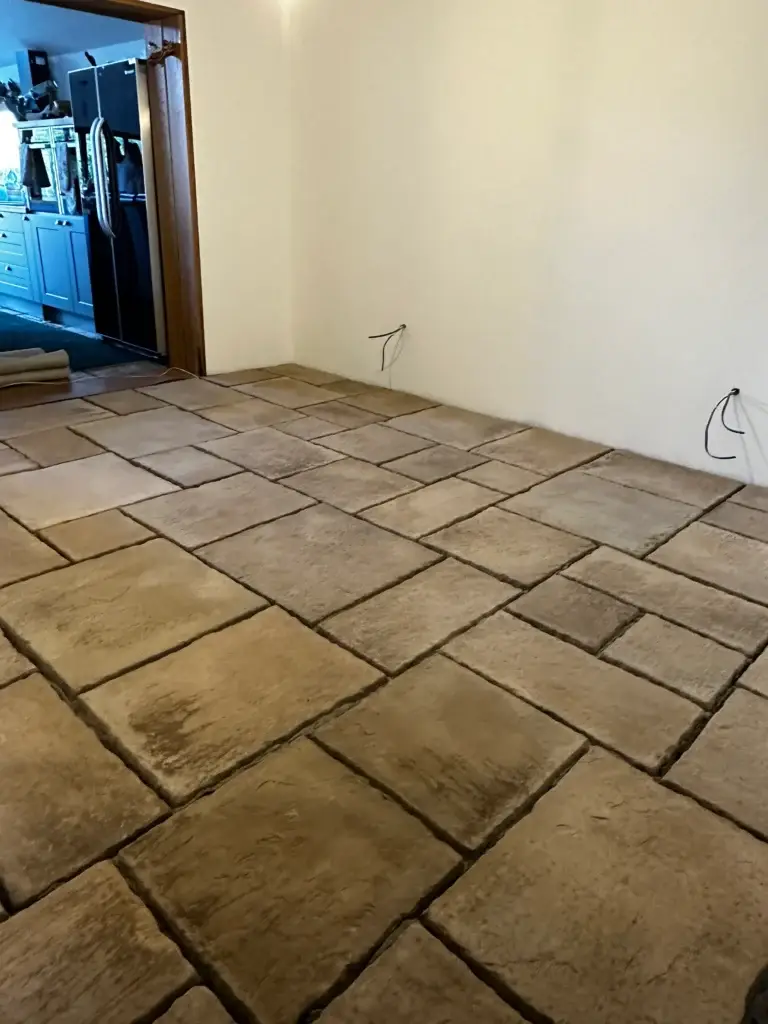 Indoor limestone floor installation with rustic hand-cut stone slabs in warm brown and beige tones, creating a natural finish. Completed by landscape gardeners in Lincoln.