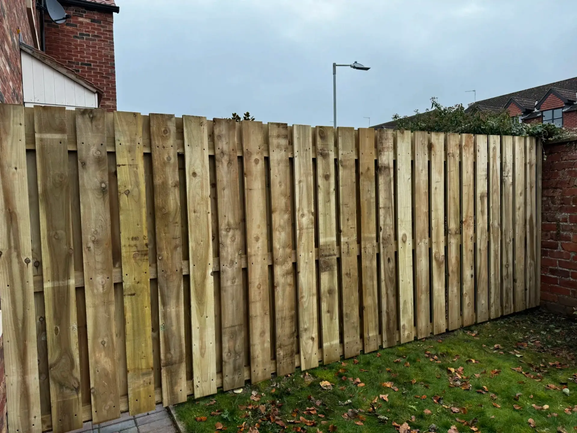 Heavy-duty vertical timber fence panels installed in a modern garden in The Elms, Torksey, Lincolnshire — pressure-treated wooden fencing by landscapers in Lincoln