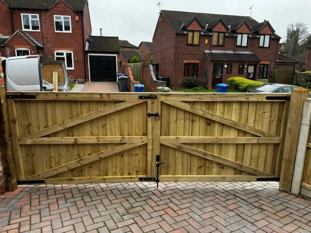 Timber driveway gates opening onto a brindle block paving driveway