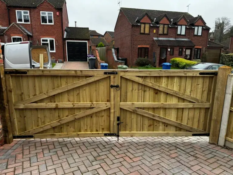 Heavy-duty wooden driveway gate installation on a block-paved entrance in Lincoln - solid timber gate design fitted by landscapers in Lincoln.