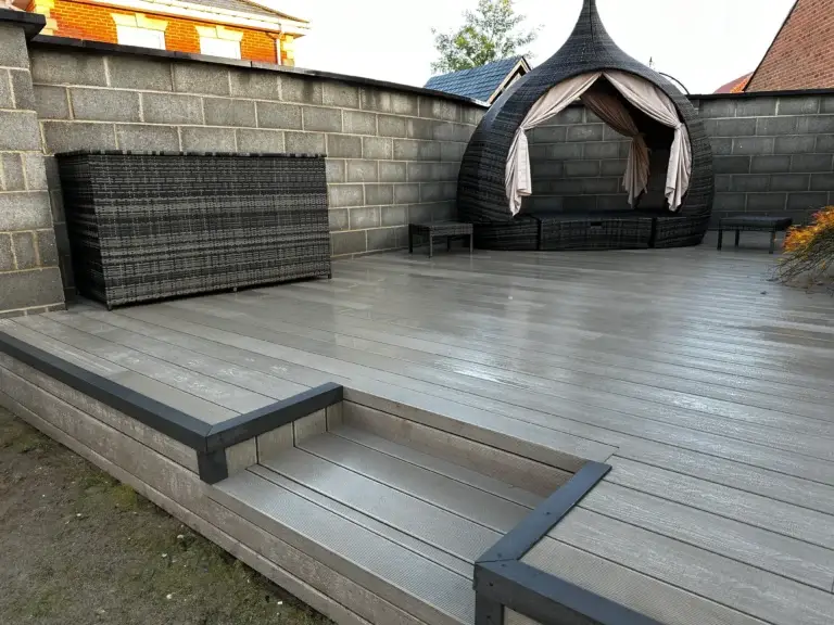 Light grey composite decking with step feature installed by garden landscapers in Lincoln, creating a modern low-maintenance garden space