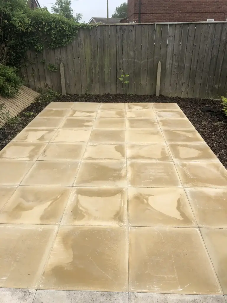 Smooth buff sandstone patio installation with clean-cut edges and freshly prepared garden borders, creating a bright and durable outdoor area. Completed bylandscape gardeners in Gainsborough, Lincolnshire.