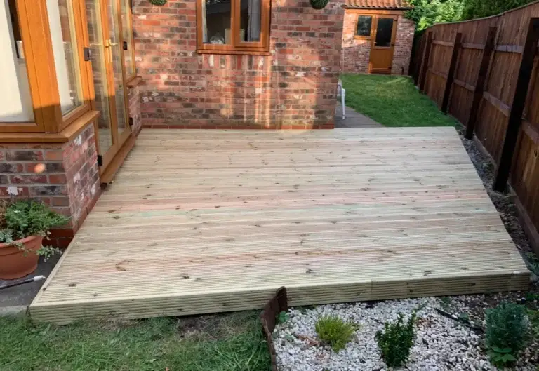 Wooden decking installation in Gainsborough garden landscapers., featuring treated softwood boards with a smooth natural finish