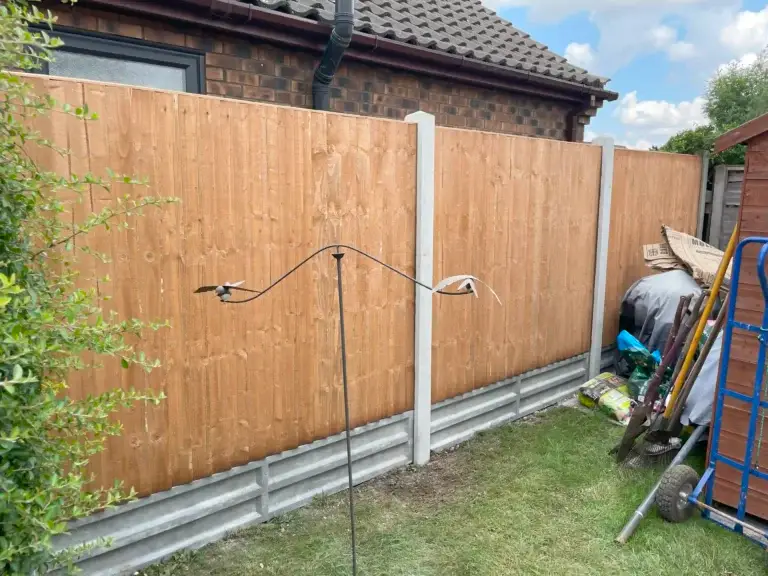 Tan-stained wooden fence panels with concrete posts and double gravel boards installed in a landscaped garden in The Elms, Torksey, Lincolnshire, fencing project by landscapers in Lincoln