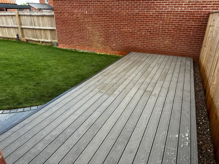 Light grey composite decking installation in Gainsborough garden landscapers in Gainsborough, featuring hidden fixings and edge detail beside new turf lawn