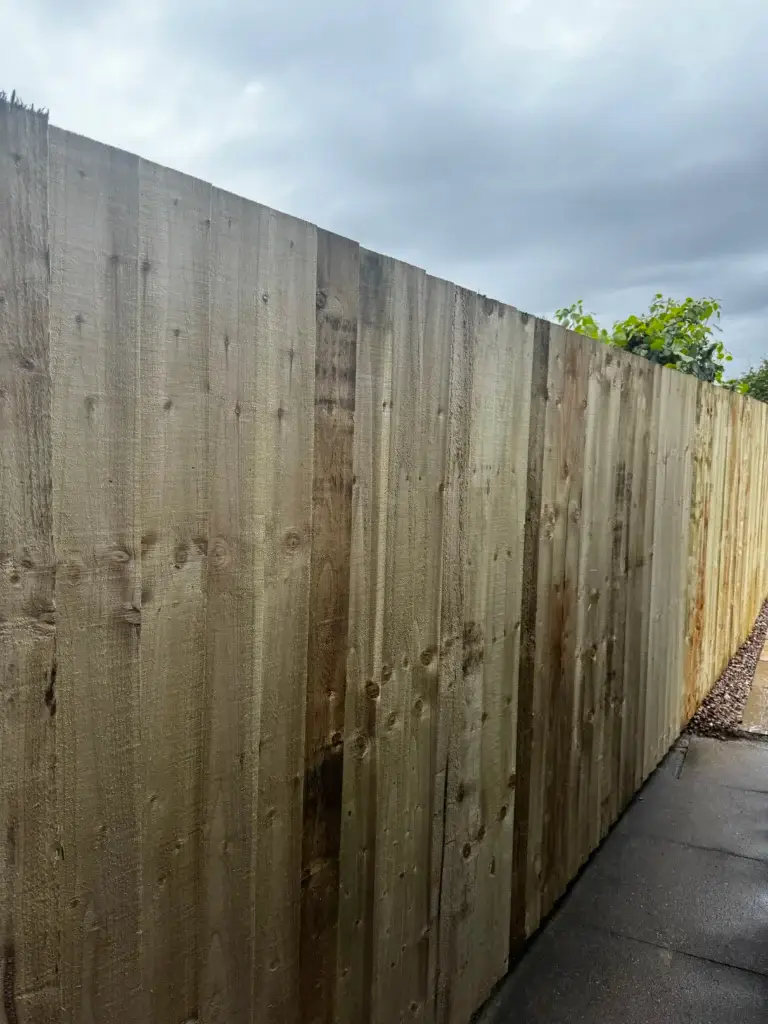 Closeboard timber fence installation with natural weathered wood finish installed along a paved pathway in The Elms, Torksey, Lincolnshire, durable garden fencing by landscapers in Lincoln