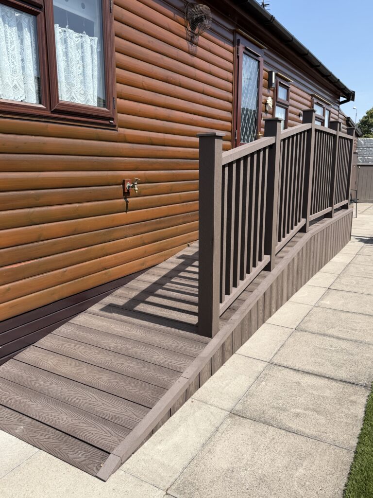 Ramped woodgrain composite decking with dark brown balustrade on a park home lodge by Lincoln composite decking installers