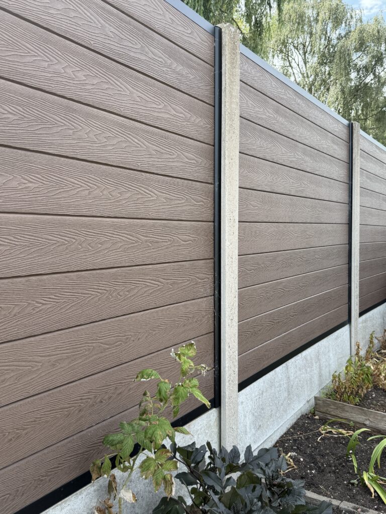Brown woodgrain composite fence panels in concrete posts with gravel boards, installed by fencing contractors in Lincoln