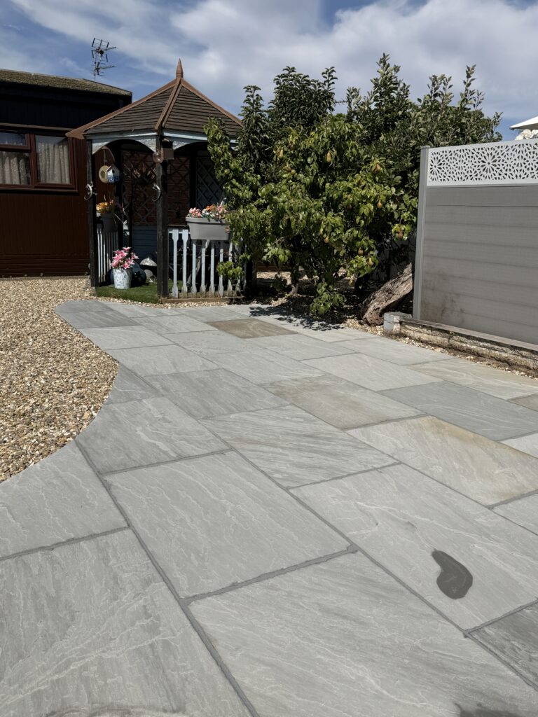 Curved grey riven paving sweeping past a gazebo and pear tree, laid by patio laying specialists in Lincoln