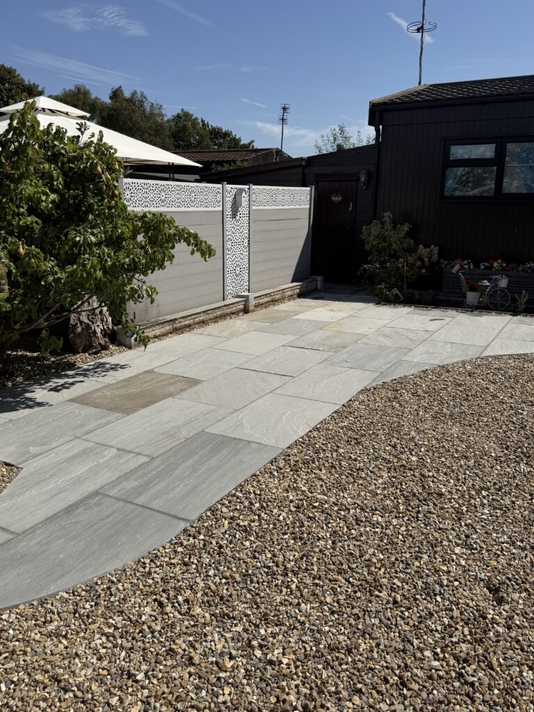 Grey composite fencing with decorative screen panels above new riven paving, by fencing installers covering Gainsborough