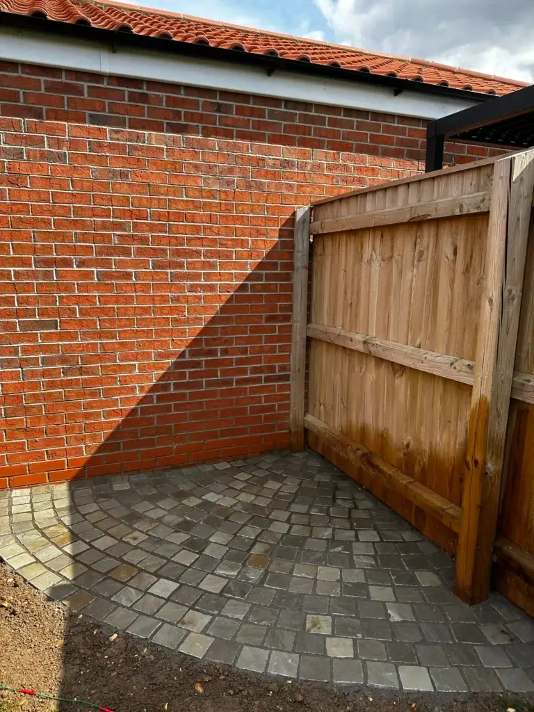 Block paving corner patio laid in grey setts