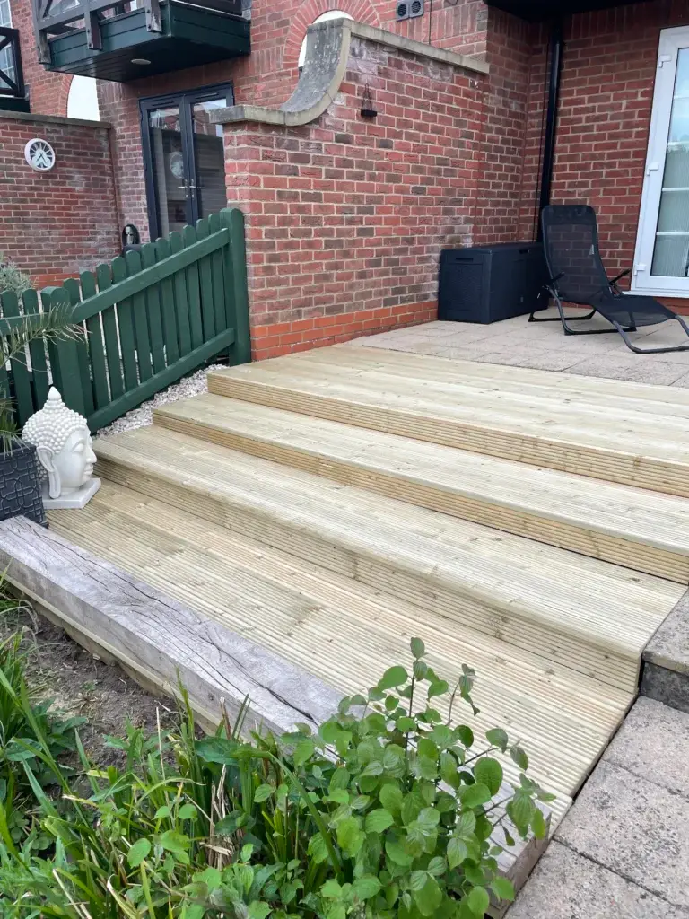 Light wooden decking installation with wide garden steps installed by landscapers in Lincoln, featuring smooth treated boards and edge detailing