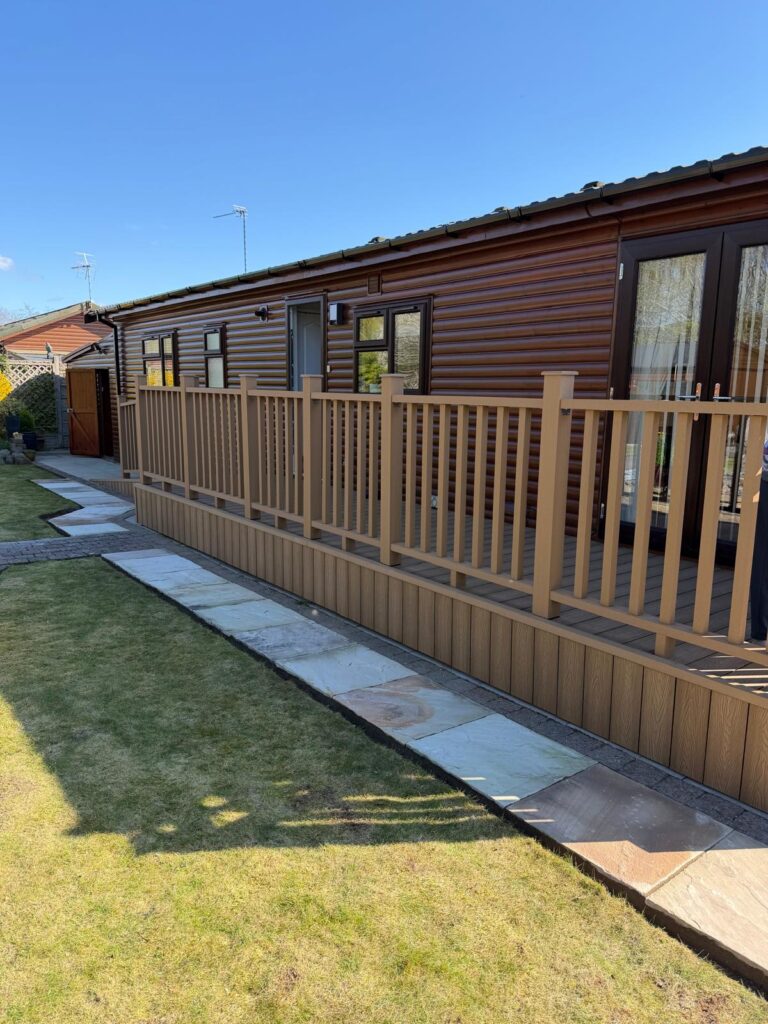 Composite decking installation with matching balustrades, skirting and stone garden pathway by landscapers in Lincoln
