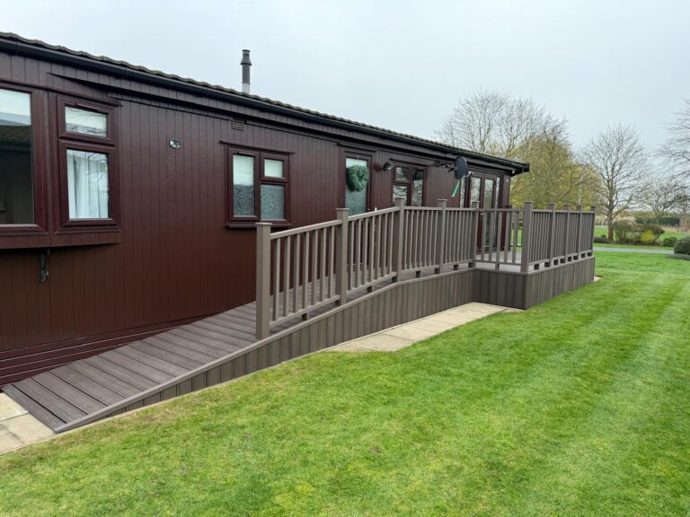 Coffee coloured modern composite decking installation with matching balustrade surround leading down onto a matching disability ramp from landscapers in Lincoln.
