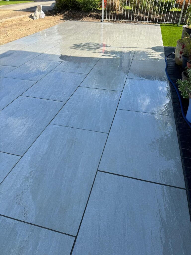 Large grey porcelain patio in Lincoln with oversized paving slabs, dark joint lines and a sleek contemporary finish.