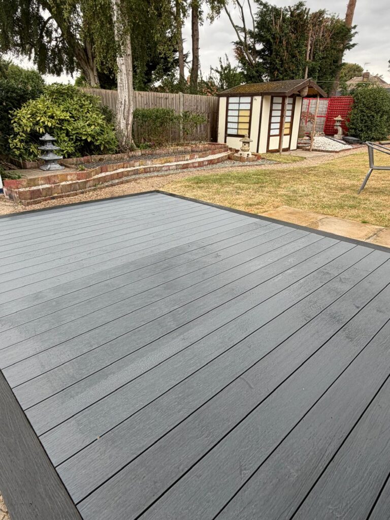 Grey composite decking beside a Japanese style garden with stone lanterns, by garden decking installers serving Gainsborough
