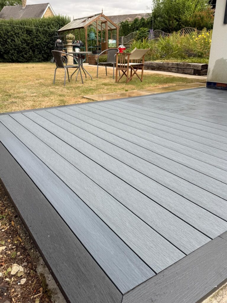 Light grey composite decking with charcoal picture frame border and fascia, laid by a Lincolnshire decking company