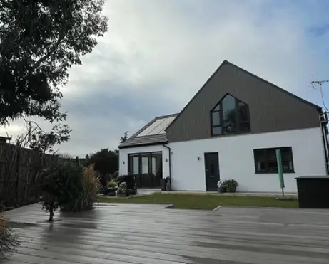 Contemporary home with modern grey porcelain patio and neat lawn area, blending outdoor living with sleek architectural design. Installed by Reshape Landscaping in Lincoln, Lincolnshire.