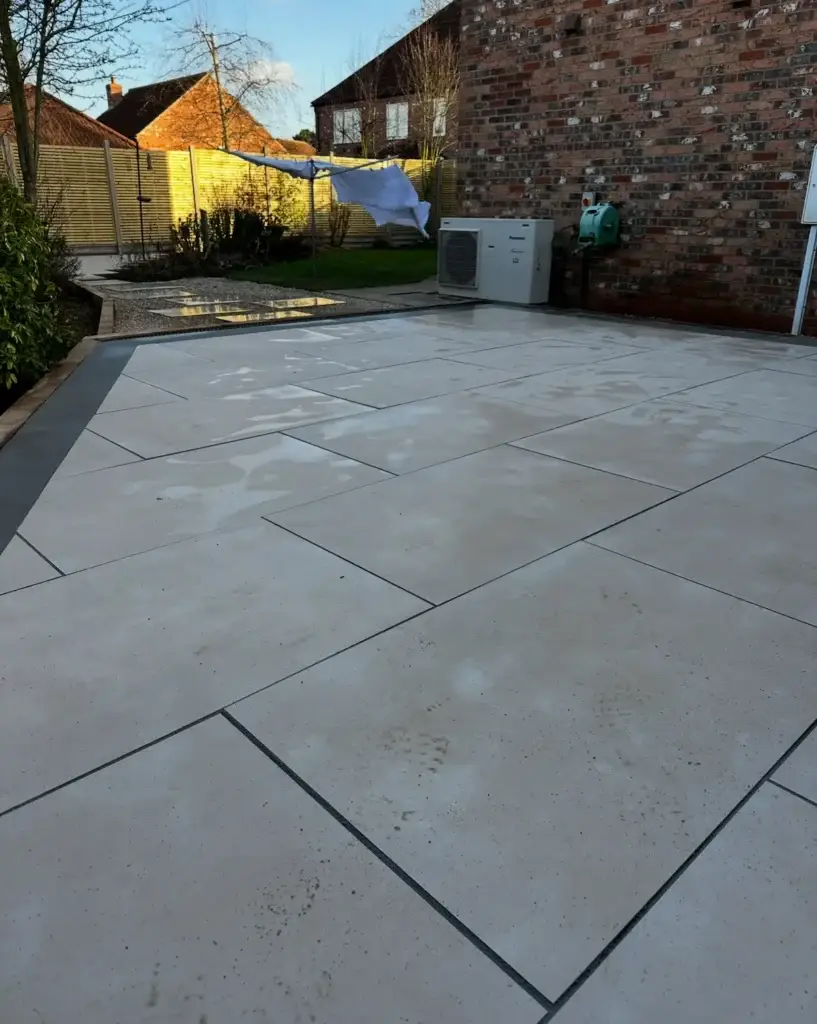 A sleek porcelain patio installation by Lincoln based garden landscapers. Featuring premium light-stone paving with precise joint lines, contemporary edging, and a clean finish.