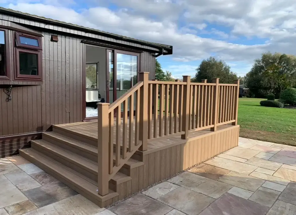 Raised composite decking installation with handrails above a cream sandstone patio, installed by landscapers in Gainsborough