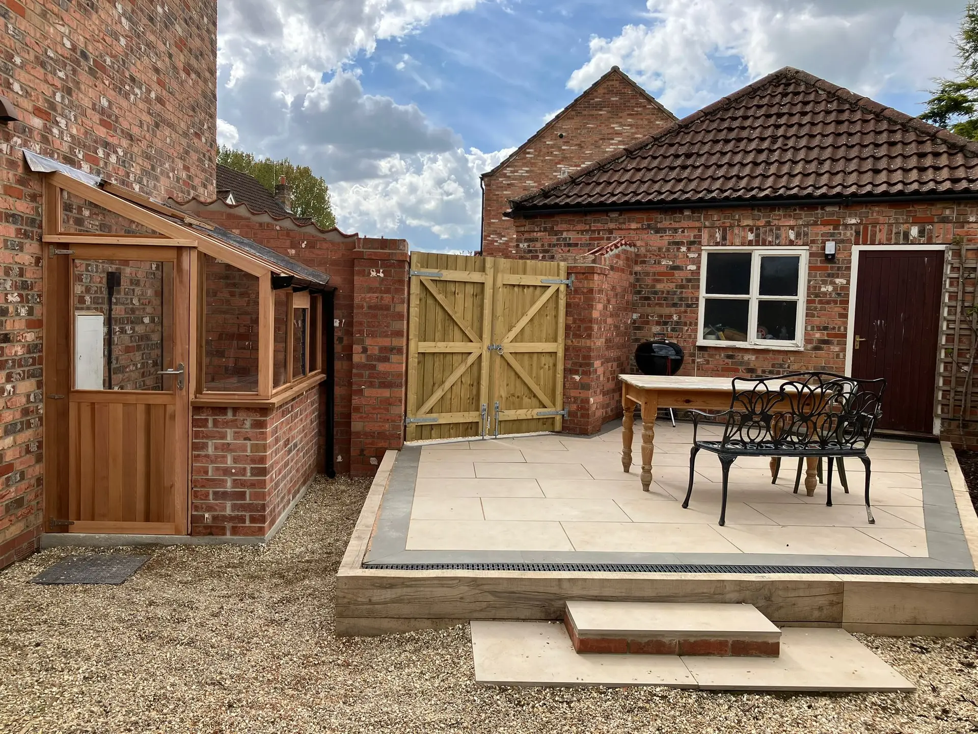 Porcelain patio installation in Lincolnshire by Reshape Landscaping Ltd, featuring raised edging, drainage detail, and a modern outdoor dining area