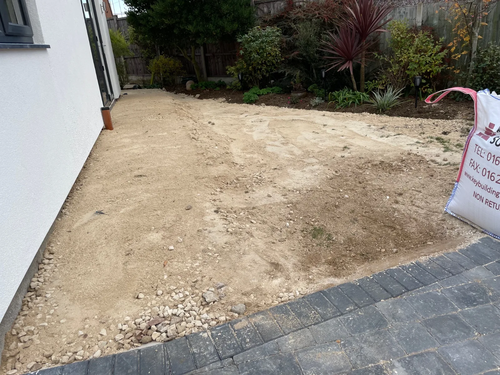 Picture of the start of a patio transformation, hardcore gravel compacted as a base for a patio installation in Lincoln.