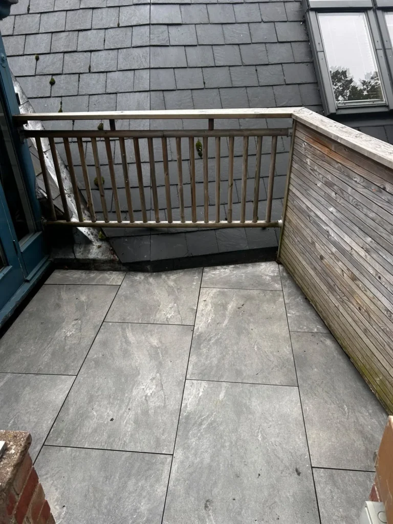 Grey porcelain paving on the balcony of an old schoolhouse in Lincoln, laid to match the patio in the garden below